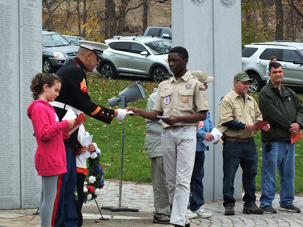 A Boy Scout from Troop 72 handed a card of appreciation to Marine Veteran Eric Simmons.